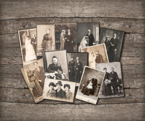 Old family photos laid out on wooden background
